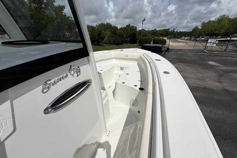 Slide: The Image of 2022 Sea Hunt Gamefish 27FS boat, white exterior, docked under cloudy skies. - 58