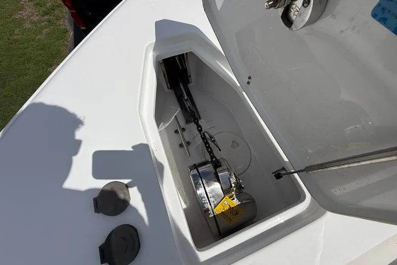 Slide: The Image of Anchor compartment of 2022 Sea Hunt Gamefish 27FS boat, open with visible chain and mechanism. - 59