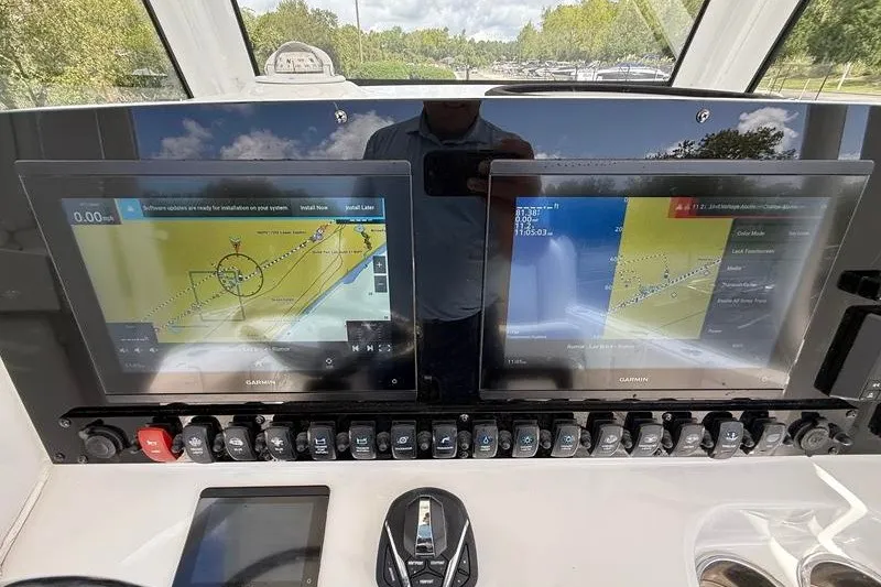Slide: The Image of 2022 Sea Hunt Gamefish 27FS dashboard with dual Garmin navigation screens and control panel. - 49
