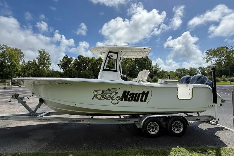 Slide: The Image of 2022 Sea Hunt Gamefish 27FS boat on trailer, parked outdoors under a blue sky. - 34