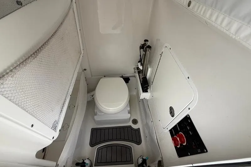 Slide: The Image of Interior of 2022 Sea Hunt Gamefish 27FS boat featuring a compact marine toilet. - 56