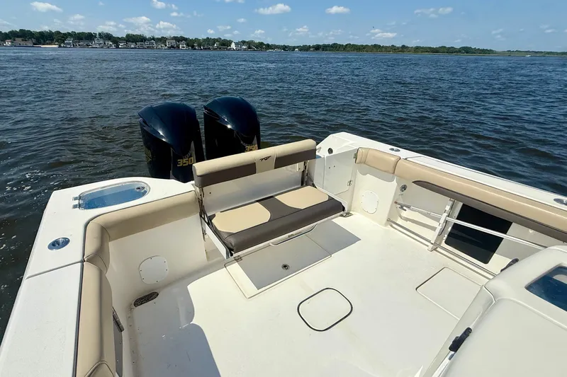 Slide: The Image of 2019 Tidewater 320 CC Adventure boat with dual engines on a calm lake. - 19