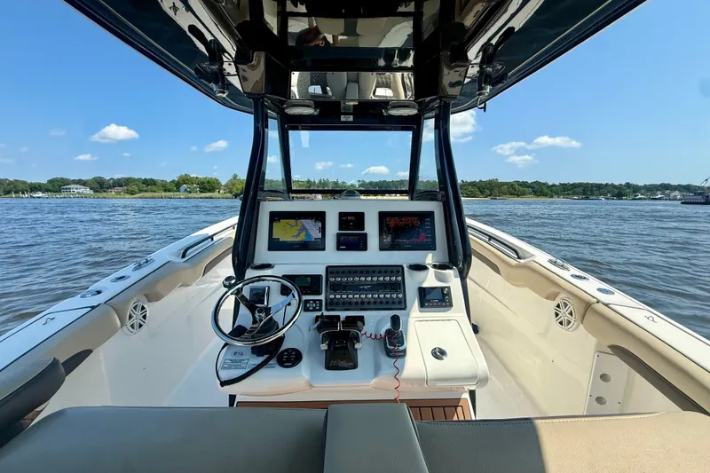 Slide: The Image of 2019 Tidewater 320 CC Adventure boat dashboard with navigation screens on a sunny day. - 14
