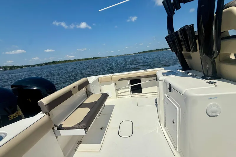 Slide: The Image of 2019 Tidewater 320 CC Adventure boat interior with seating, ocean view, and dual engines. - 18