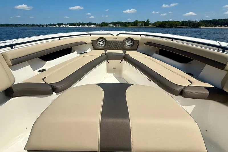 Slide: The Image of 2019 Tidewater 320 CC Adventure boat interior with beige seating on a sunny day. - 30