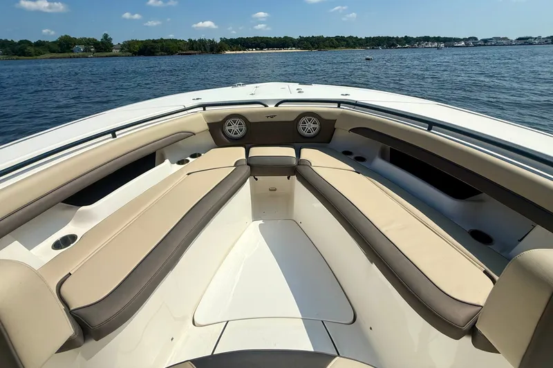 Slide: The Image of 2019 Tidewater 320 CC Adventure boat interior with beige seating on a sunny day. - 29