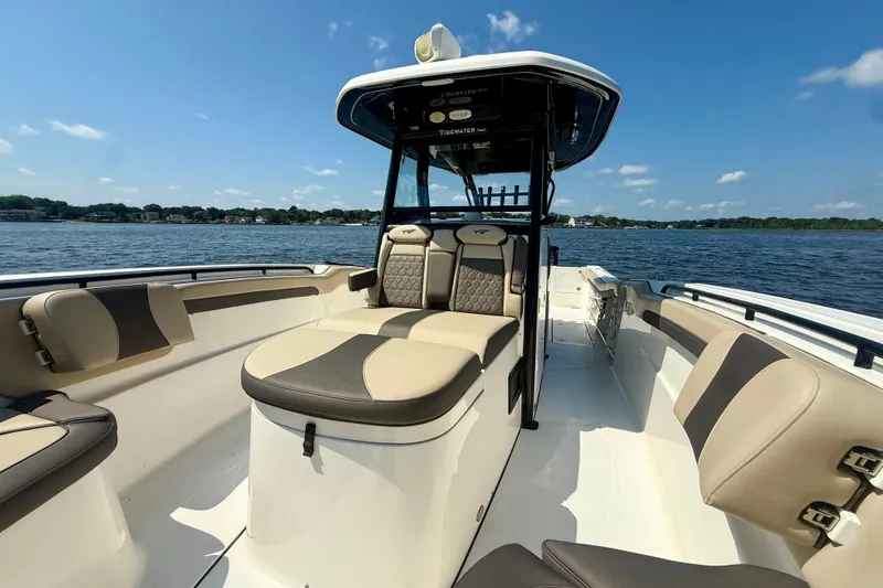 Slide: The Image of 2019 Tidewater 320 CC Adventure boat interior with seating, on a sunny day by the water. - 27