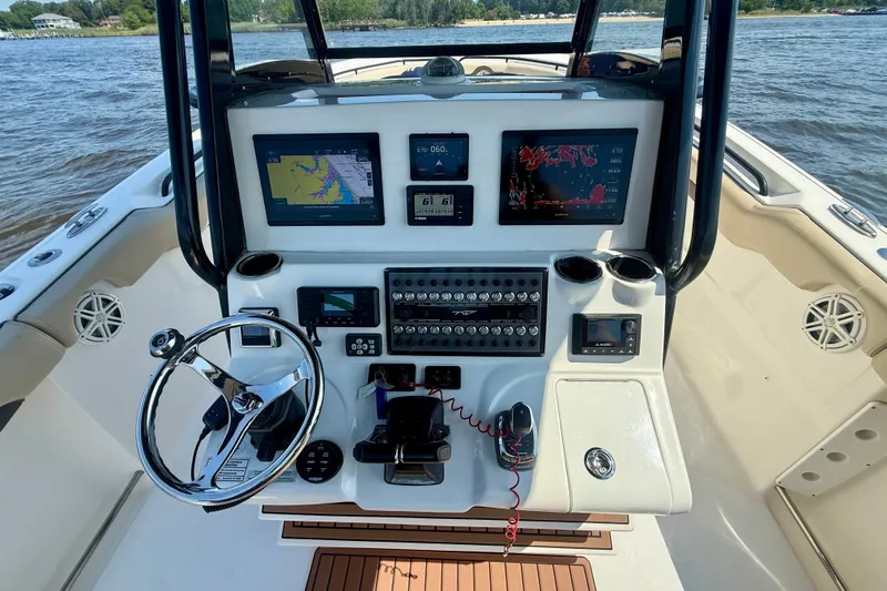 Slide: The Image of 2019 Tidewater 320 CC Adventure boat dashboard with navigation screens and controls. - 13