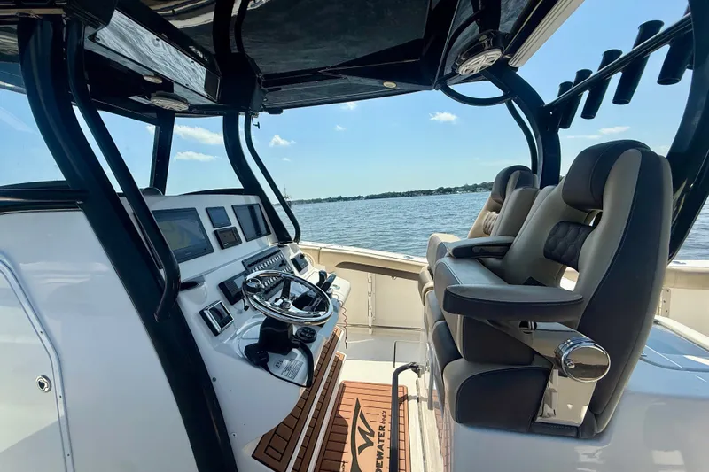 Slide: The Image of 2019 Tidewater 320 CC Adventure boat cockpit with modern controls and seating, overlooking the water. - 21