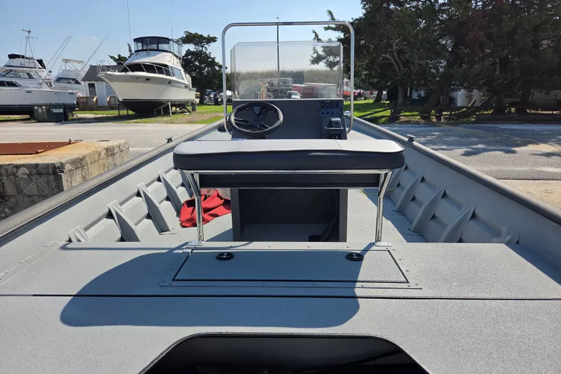 Slide: The Image of 2026 SeaArk 2072 Workhorse boat with console and seating, docked outdoors. - 8