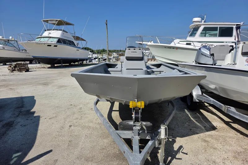 Slide: The Image of 2025 SeaArk 1872 MVT boat on trailer in marina, surrounded by other boats. - 5