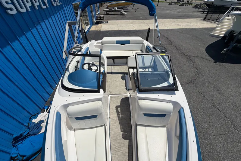Slide: The Image of 2016 Regal 1900 ESX Bowrider boat with blue accents, docked near a blue building. - 9