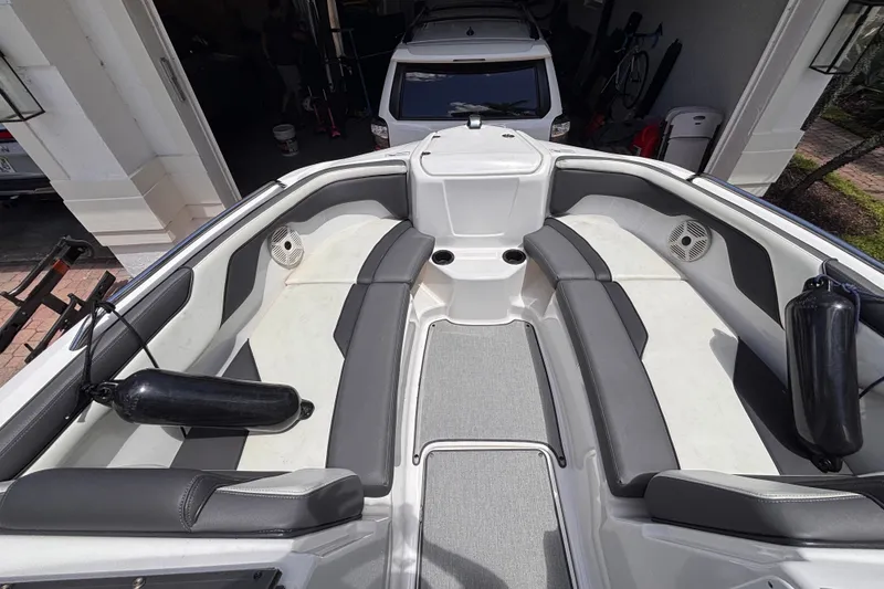 Slide: The Image of 2022 Yamaha Boats AR210 interior with gray seating and cup holders. - 30