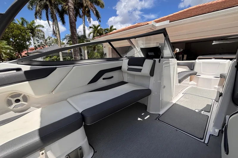 Slide: The Image of 2022 Yamaha AR210 boat interior with sleek seating and modern design under a sunny sky. - 35