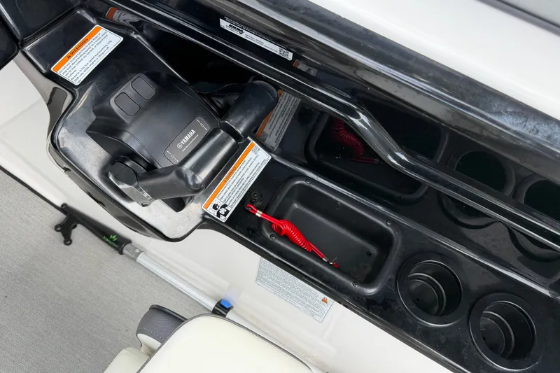Slide: The Image of Control panel of 2022 Yamaha Boats AR210 with throttle and cup holders. - 24