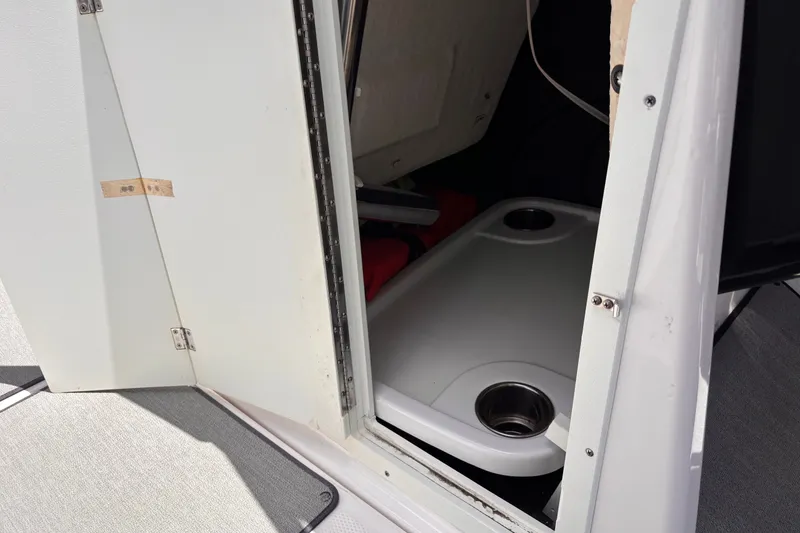 Slide: The Image of 2022 Yamaha AR210 boat interior storage compartment with table and cup holders. - 41