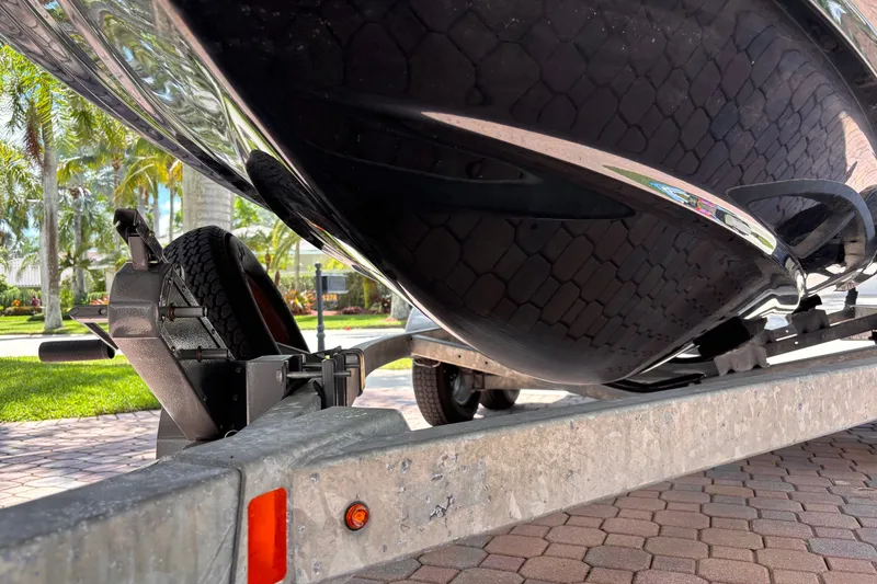 Slide: The Image of 2022 Yamaha AR210 boat on trailer, close-up view, parked on brick driveway. - 47