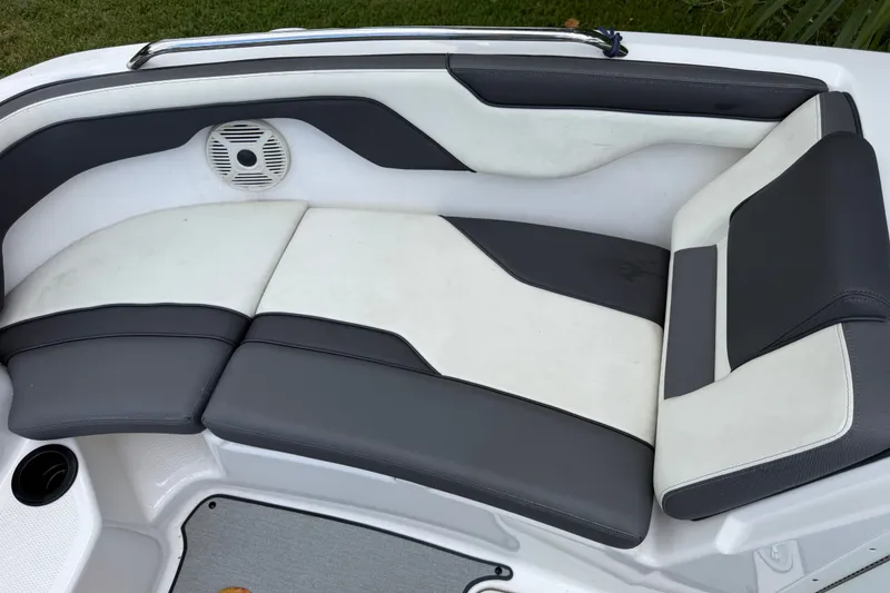 Slide: The Image of 2022 Yamaha Boats AR210 interior seating with gray and white upholstery. - 26