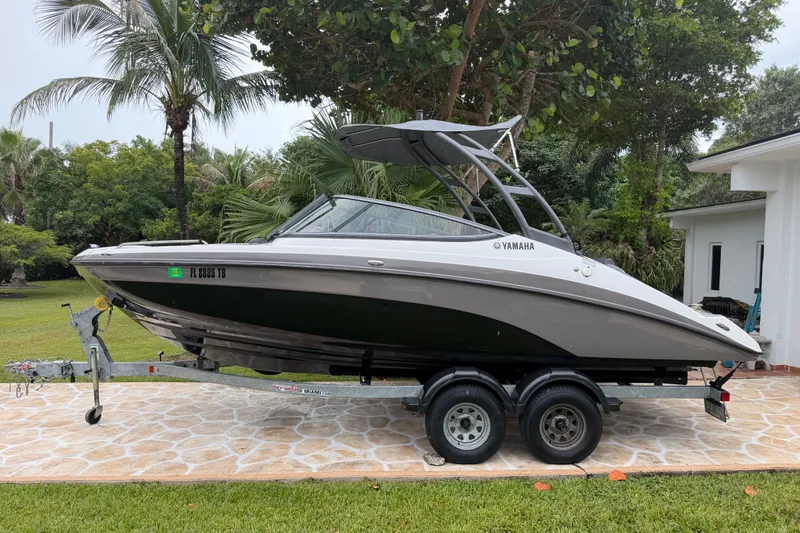 Slide: The Image of 2022 Yamaha Boats AR210 on trailer, parked outdoors with lush greenery background. - 3