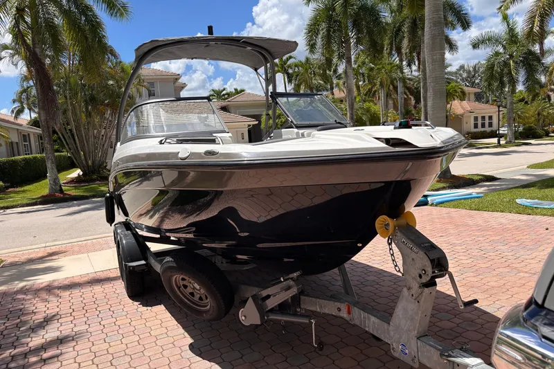 Slide: The Image of 2022 Yamaha Boats AR210 on trailer, parked in a sunny residential area. - 5
