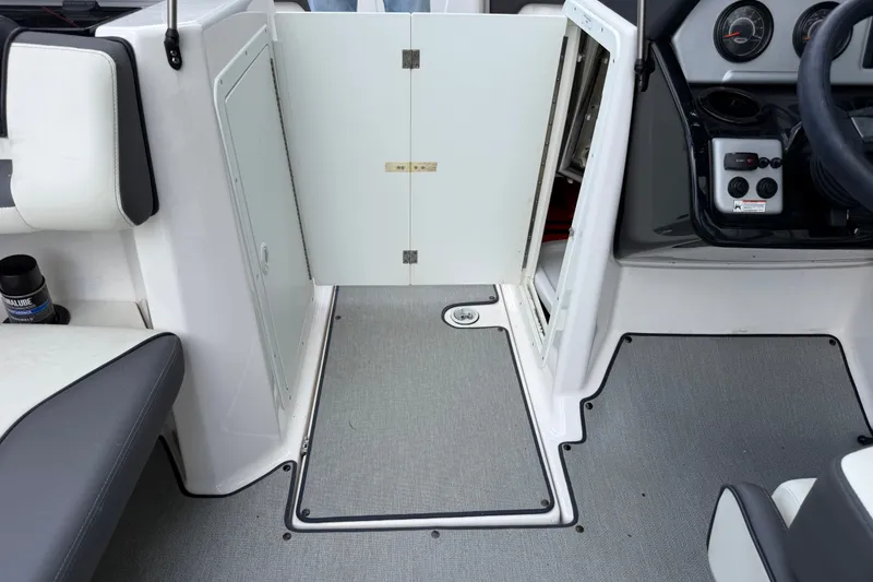 Slide: The Image of 2022 Yamaha AR210 boat interior with open storage compartment and control panel. - 29
