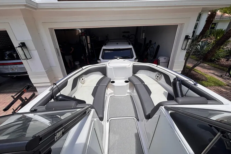 Slide: The Image of 2022 Yamaha Boats AR210 in a garage, showcasing sleek interior seating and design. - 29