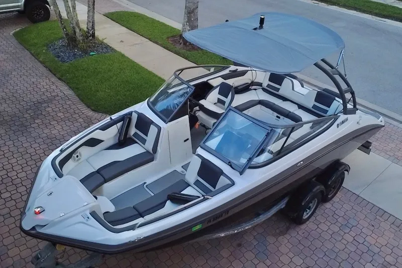 Slide: The Image of 2022 Yamaha Boats AR210 on trailer, featuring sleek design and spacious seating. - 12