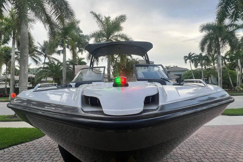 Slide: The Image of 2022 Yamaha AR210 boat docked, surrounded by palm trees, showcasing sleek design. - 10