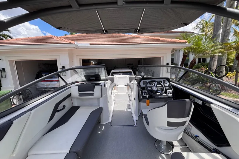 Slide: The Image of 2022 Yamaha Boats AR210 interior view, showcasing sleek seating and modern dashboard design. - 26