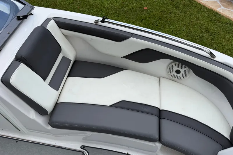 Slide: The Image of 2022 Yamaha AR210 boat interior with sleek black and white seating and speaker. - 12