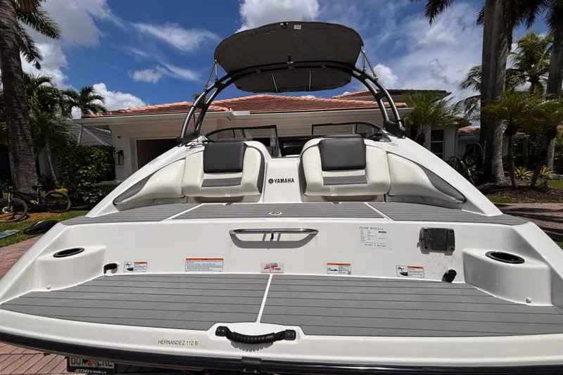 Slide: The Image of 2022 Yamaha Boats AR210 with sleek design, parked outdoors under a clear blue sky. - 19
