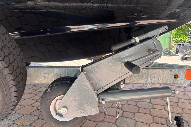 Slide: The Image of 2022 Yamaha Boats AR210 trailer hitch and wheel on paved surface. - 51