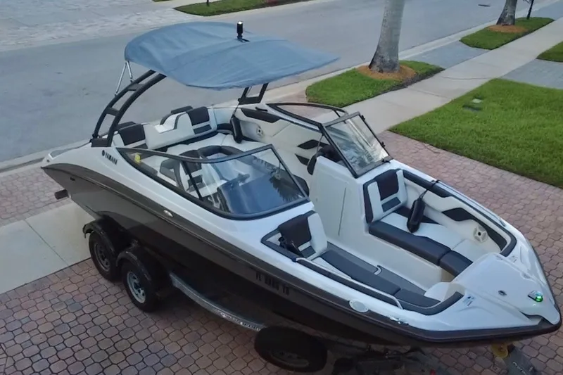 Slide: The Image of 2022 Yamaha Boats AR210 on trailer, parked on a paved driveway. - 13