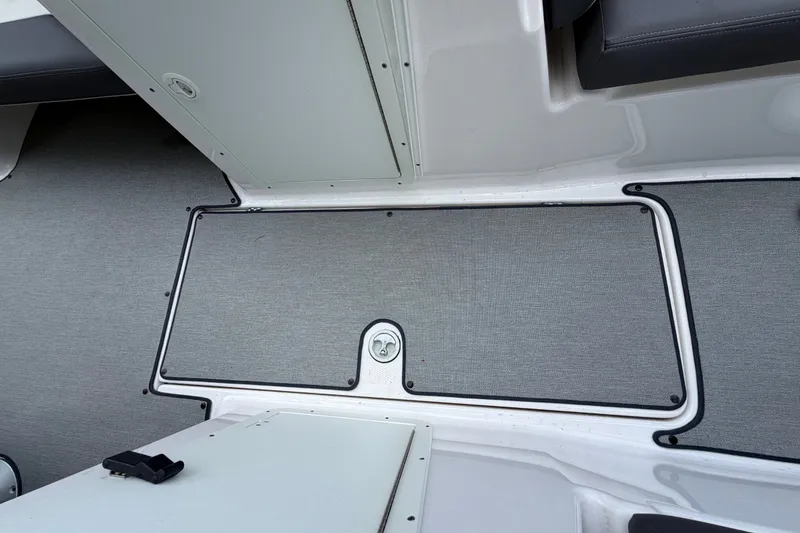 Slide: The Image of 2022 Yamaha AR210 boat interior with gray flooring and storage compartment. - 30