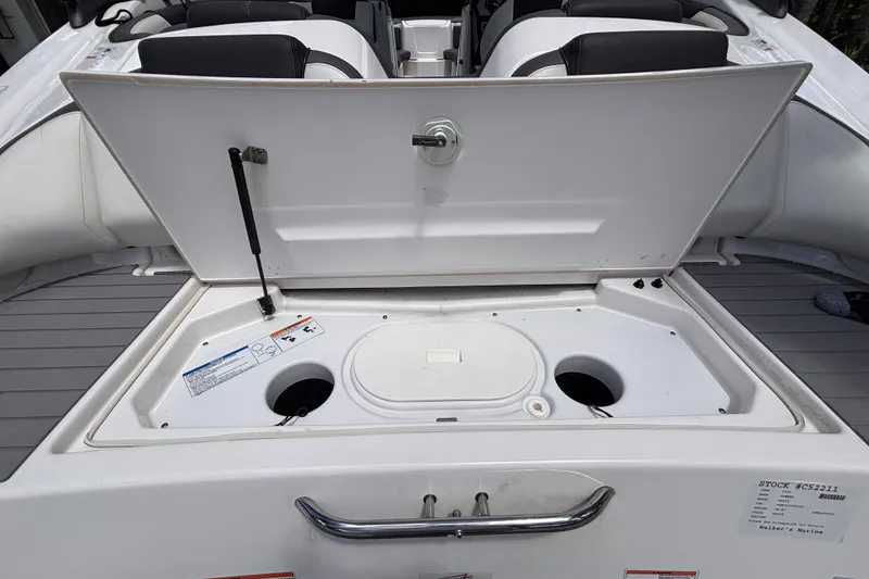 Slide: The Image of 2022 Yamaha Boats AR210 storage compartment open, showcasing interior features and seating arrangement. - 24