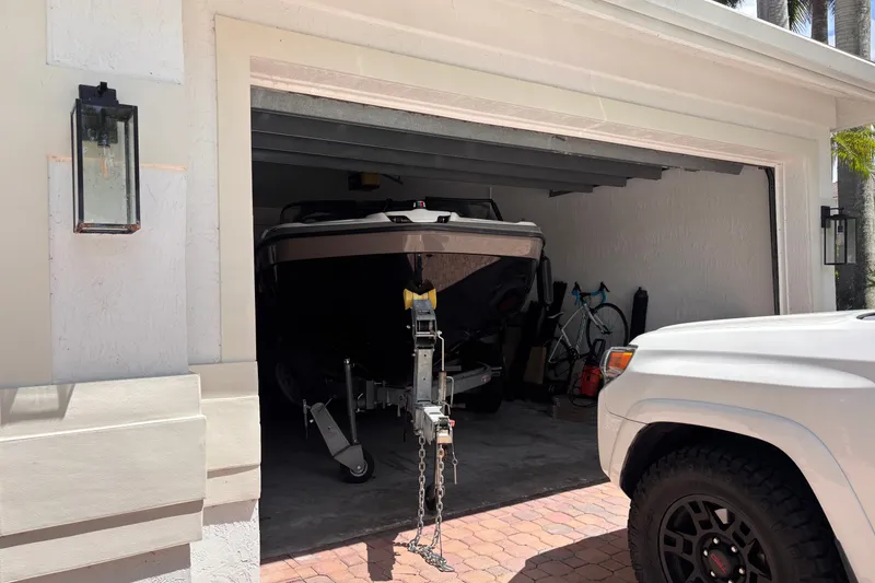 Slide: The Image of 2022 Yamaha AR210 boat stored in a garage with a white vehicle nearby. - 55
