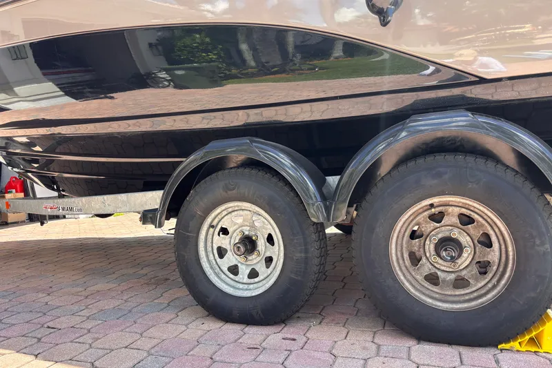 Slide: The Image of 2022 Yamaha Boats AR210 on trailer, showcasing dual wheels on a paved surface. - 46