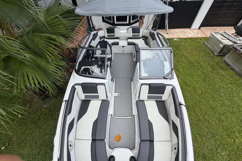 Slide: The Image of 2022 Yamaha AR210 boat with sleek seating, canopy, and modern design on grass. - 5