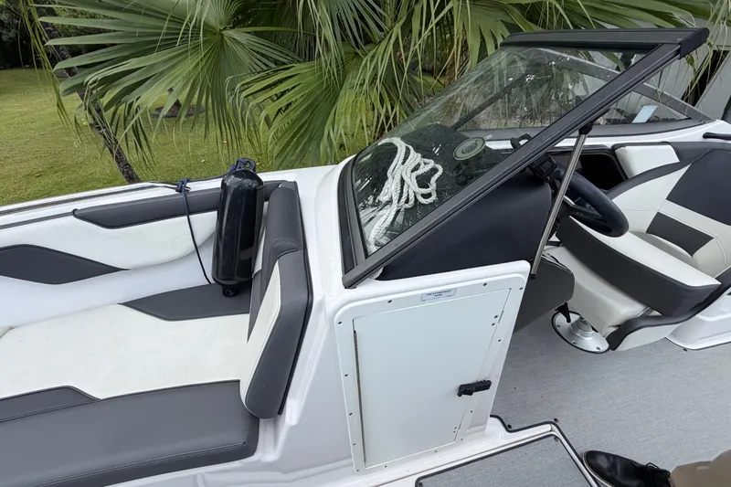 Slide: The Image of 2022 Yamaha AR210 boat interior with seating, steering wheel, and palm trees in the background. - 27