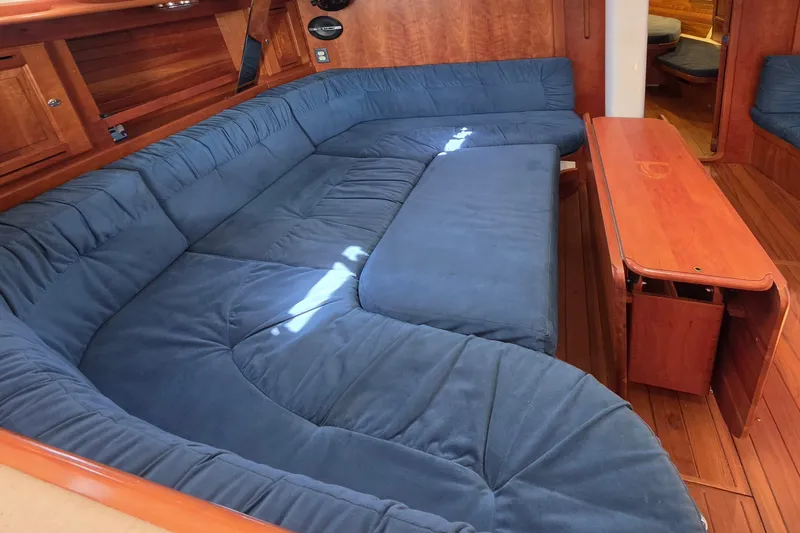 Slide: The Image of Luxurious interior of 2008 Tartan 4300 yacht with blue cushioned seating and wooden table. - 25
