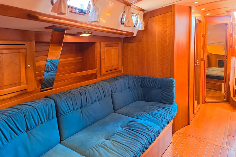 Slide: The Image of Luxurious 2008 Tartan 4300 yacht interior with blue seating and wooden cabinetry. - 23