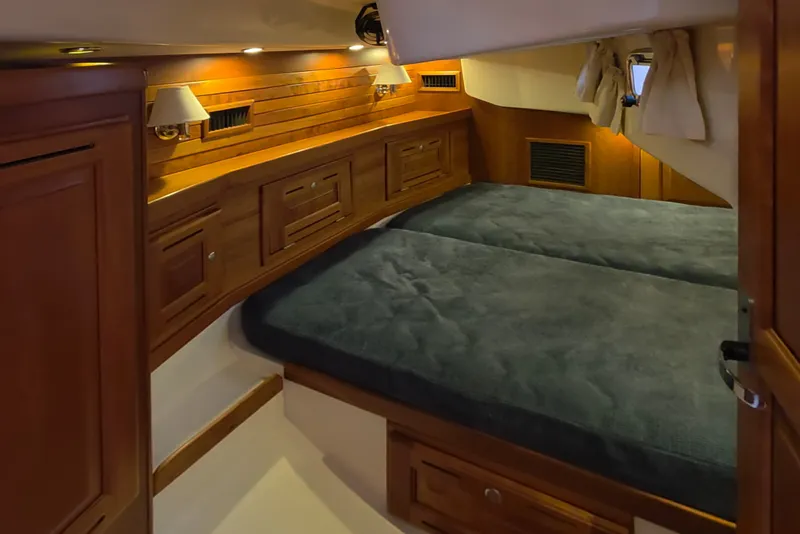 Slide: The Image of The 2008 Tartan 4300 cabin features a cozy double bed with wooden furnishings and lighting. - 38