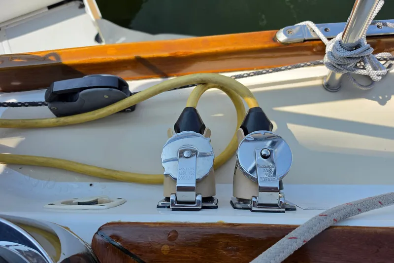 Slide: The Image of Power connectors on a 2008 Tartan 4300 sailboat deck, featuring chrome covers and yellow cables. - 19