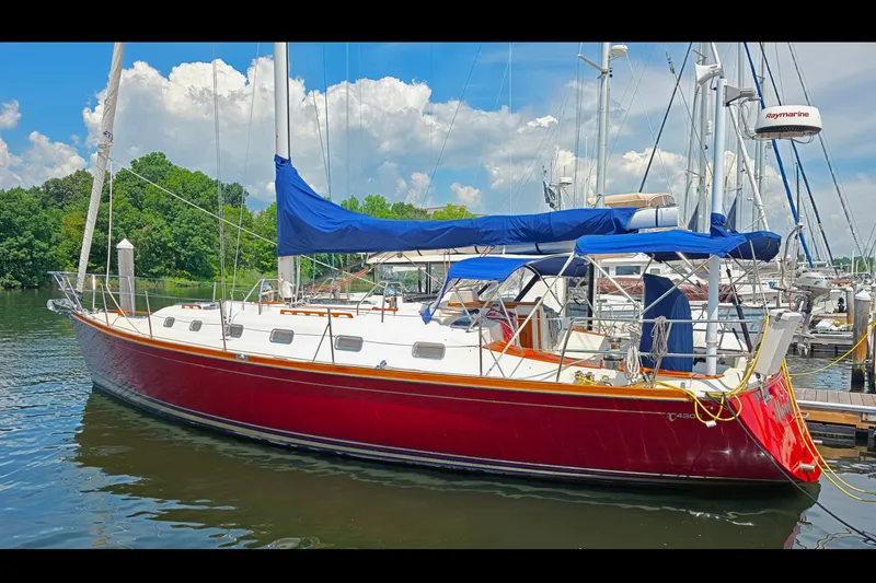 Slide: The Image of Red Tartan 4300 sailboat docked, 2008 model, with blue covers, under a sunny sky. - 1