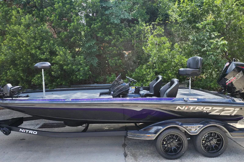Slide: The Image of 2027 Nitro Z21 XL Pro bass boat with sleek design and dual seats, parked outdoors. - 2