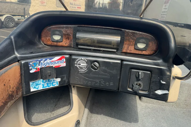 Slide: The Image of Dashboard of a 2003 Gambler 2100 boat with fishing-themed stickers and controls. - 20