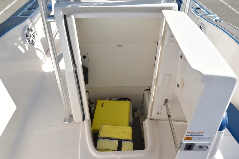 Slide: The Image of 2016 Robalo R200 Center Console boat storage compartment with yellow life jackets. - 22