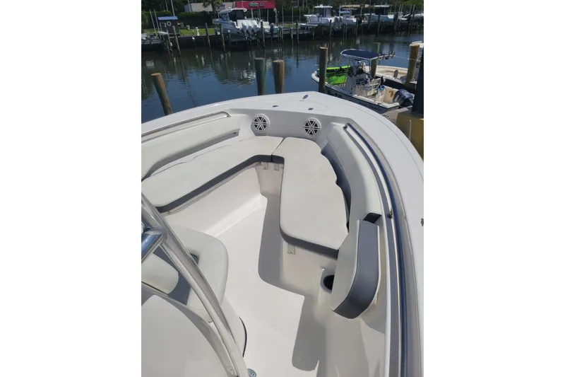 Slide: The Image of 2020 Tidewater 198 CC Adventure boat interior with cushioned seating, docked by the water. - 5