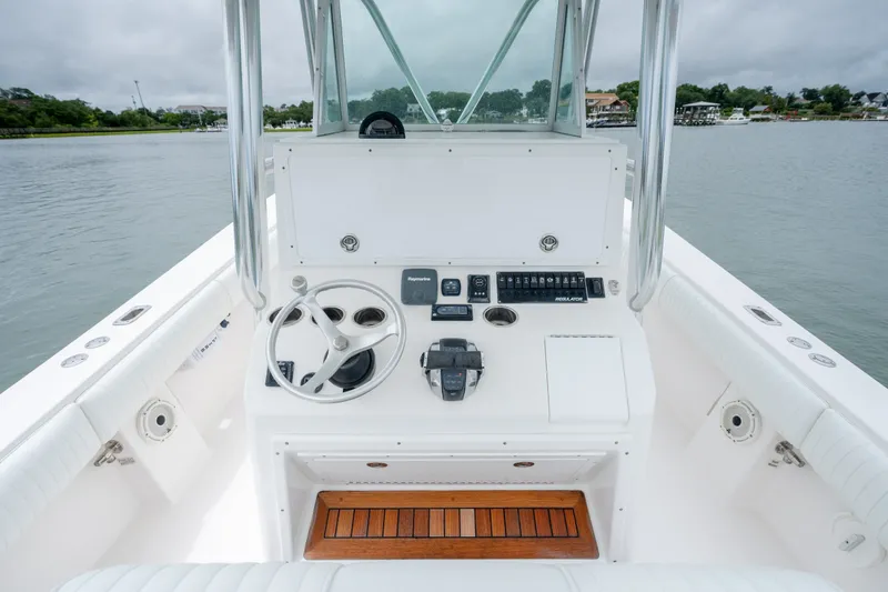 Slide: The Image of 2008 Regulator 29 Forward Seating boat helm with steering wheel and controls on calm water. - 22