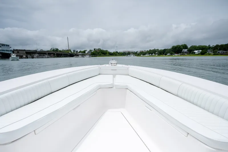 Slide: The Image of 2008 Regulator 29 Forward Seating boat on calm water, featuring spacious white seating. - 28